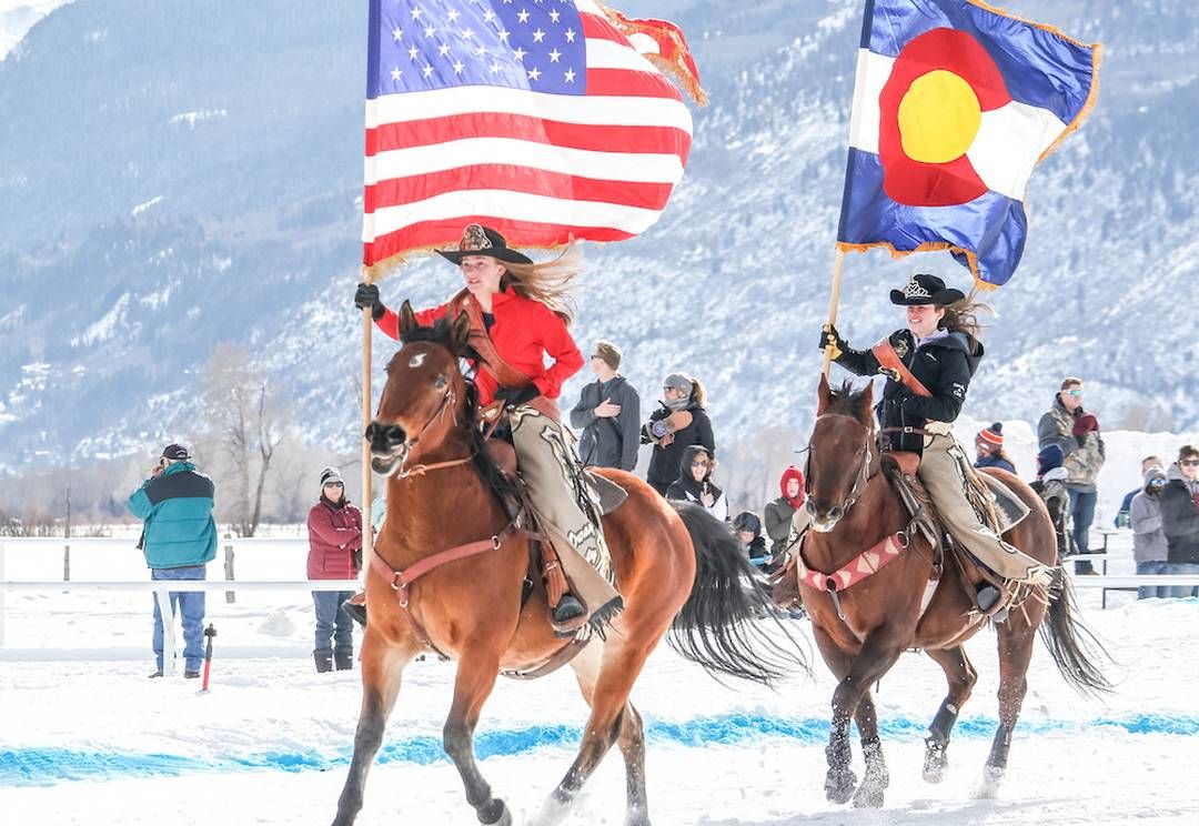 Image of horses with riders carrying flags